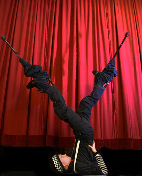 stilt walkers performing next to the red curtain in newcastle, australia, stilt acrobatics, circus performer
