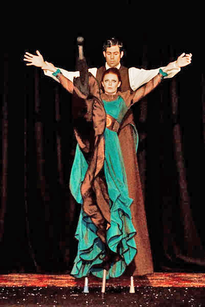 stilt character entertains with a high kick during a circus stilt dance